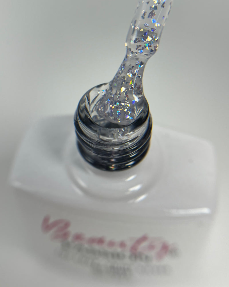 Pinceau de vernis laissant apparaître la texture transparente et les éclats de feuilles d’argent du Top Coat Silver.